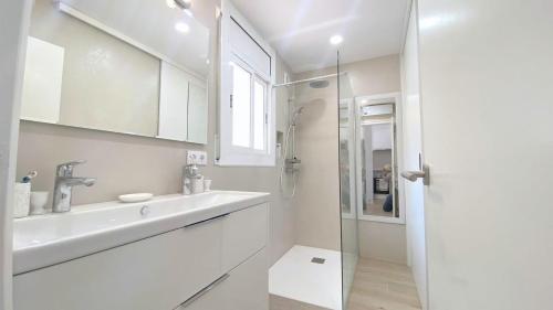 a white bathroom with a sink and a shower at Acapulco b5 in Roses