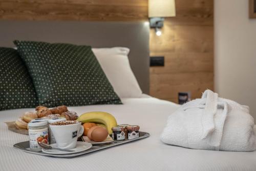 a tray of breakfast food on a bed at Les Plaisirs d'Antan in Aosta