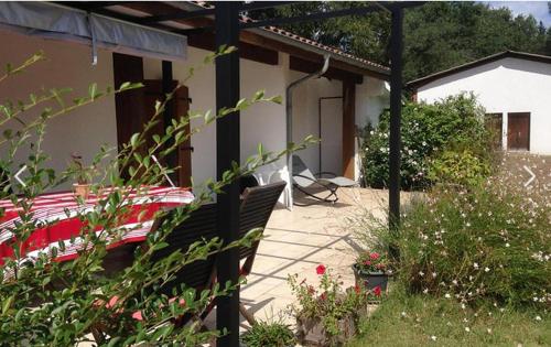 un patio d'une maison avec une table et des chaises dans l'établissement Belle de jour, à Mézos