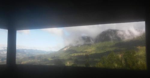 a window with a view of a misty mountain at Cabana do Camelo in São Bento do Sapucaí