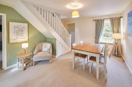 a dining room with a table and chairs and a staircase at Host & Stay - Melody's Cottage in Belford