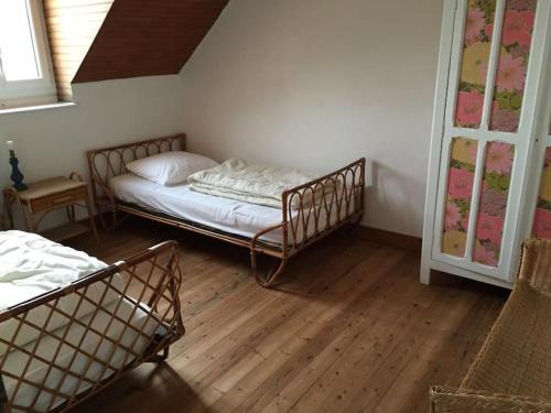 une chambre avec deux lits et un parquet dans l'établissement Les Picantins de Cayeux sur mer, à Cayeux-sur-Mer