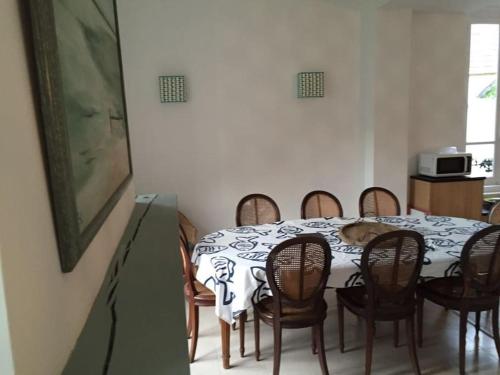 d'une table à manger et de chaises avec un chien. dans l'établissement Les Picantins de Cayeux sur mer, à Cayeux-sur-Mer