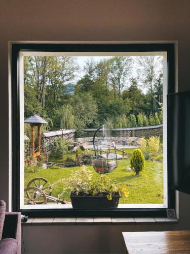 a window with a view of a garden through it at Glodeanca in Glod