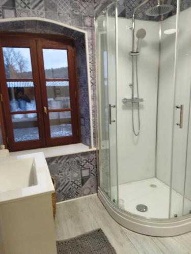 une salle de bain avec douche et lavabo dans l'établissement Chez Gustou, à Domeyrat