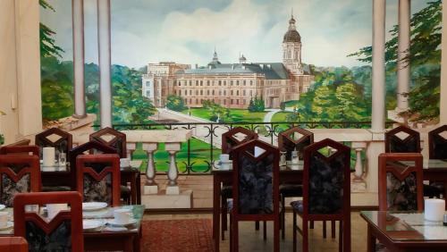uma sala de jantar com um mural de um edifício em Hotel Haegert em Neustrelitz