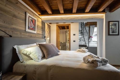 a bedroom with a bed with two towels on it at Les Plaisirs d'Antan in Aosta