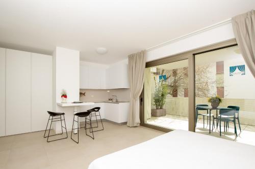 a kitchen and living room with chairs and a table at Ariston Teatro Luxury Aparthotel in Grado