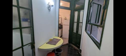 Baño pequeño con puerta verde y lavabo en San Telmo Apartment en Buenos Aires