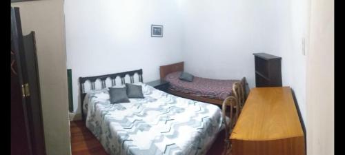 Un dormitorio con una cama y una mesa. en San Telmo Apartment en Buenos Aires