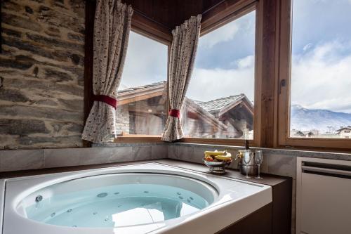 a bath tub in a room with a window at Les Plaisirs d'Antan in Aosta
