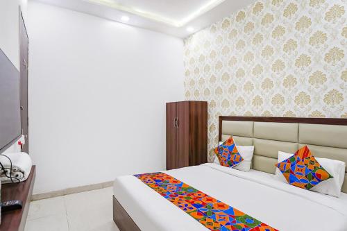 a bedroom with a bed and a wall at FabHotel Swess in Agra