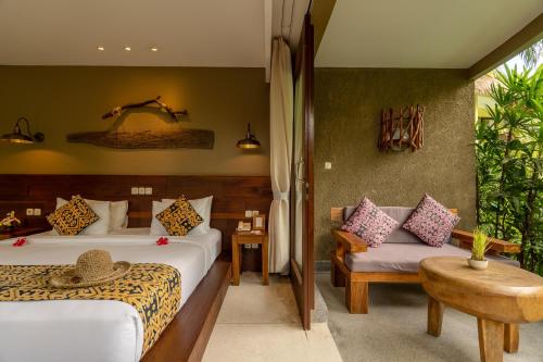 a hotel room with two beds and a couch at Honai Resort in Ubud