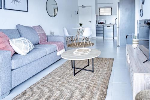 a living room with a couch and a table at Ballito Village Luxury Apartments in Ballito
