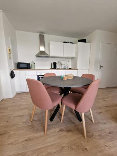 - une table à manger avec des chaises roses dans la cuisine dans l'établissement appartement t3, à Argelès-sur-Mer