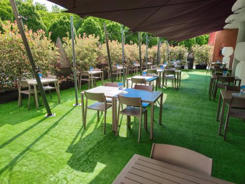 a row of tables and chairs on the grass at Just Hotel Lomazzo Fiera in Lomazzo
