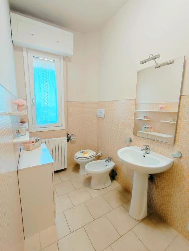 ein Badezimmer mit einem Waschbecken, einem WC und einem Spiegel in der Unterkunft Stanza privata a Brescia in Brescia
