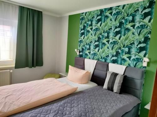 a bedroom with a bed and a green wall at Hotel Haegert in Neustrelitz