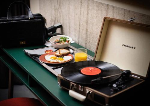 a table with a plate of food and a record at Design-Hotel JAMS in Munich