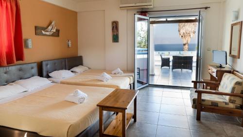 two beds in a room with a view of the ocean at Aithrio Hotel in Niforeika