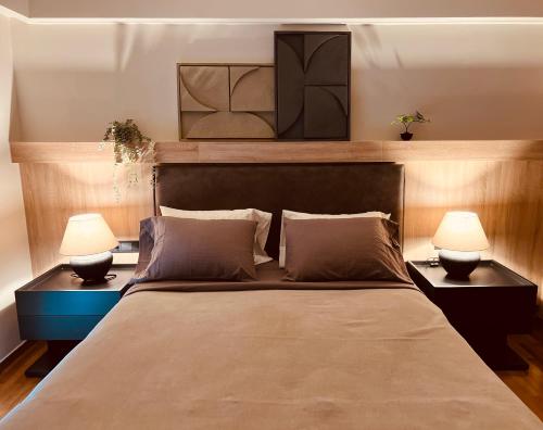 a bedroom with a large bed with two lamps at 2 BedRoom Apt - Live Like a Local in Kolonaki in Athens