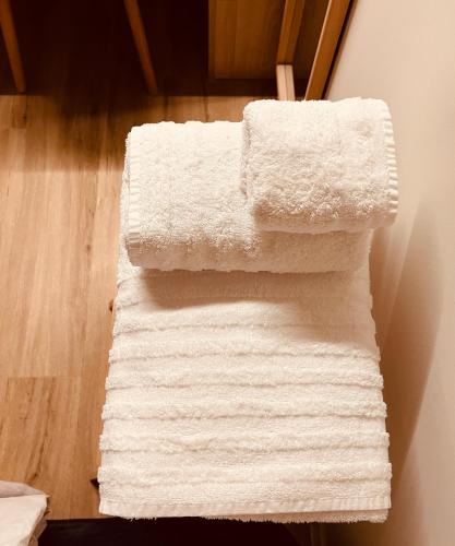 a pile of white towels sitting on the floor at 2 BedRoom Apt - Live Like a Local in Kolonaki in Athens
