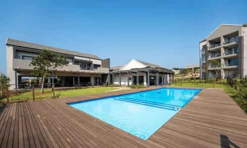 a swimming pool in front of a building at Ballito Village Luxury Apartments in Ballito