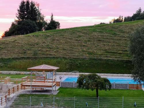 Blick auf einen Pool mit Sonnenschirm in der Unterkunft Ferienwohnungen Neukirchen in Neukirchen am Teisenberg