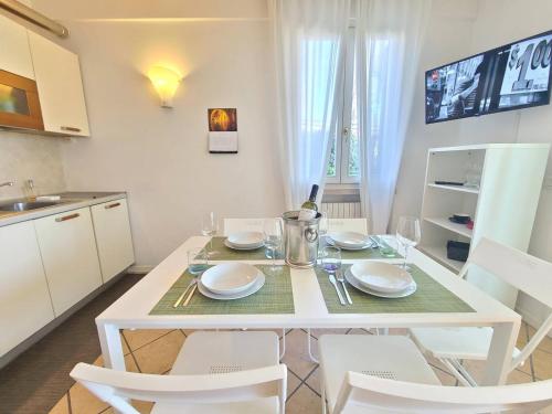 a kitchen with a white table and white chairs at Sandra Apartment in Lonato del Garda