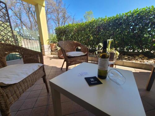 a bottle of wine on a table on a patio at Sandra Apartment in Lonato del Garda