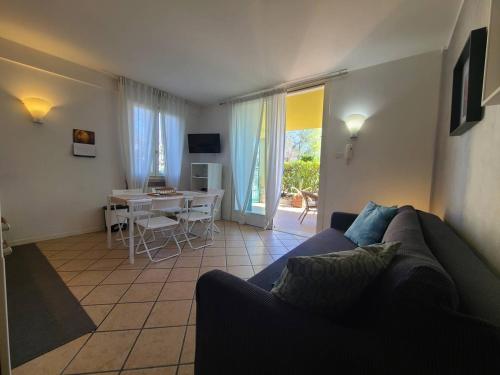 a living room with a couch and a dining room with a table at Sandra Apartment in Lonato del Garda