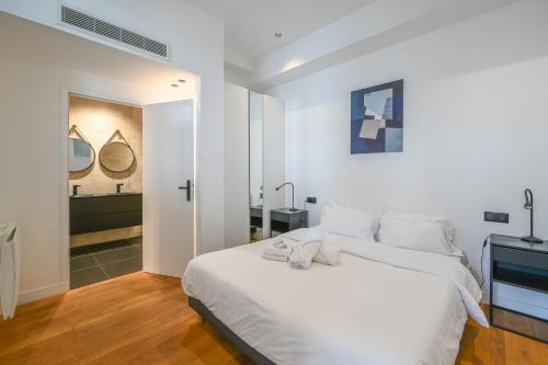 une chambre avec un lit blanc et une salle de bain dans l'établissement Appartement de Prestige - Grand Varenne, à Paris