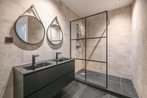 une salle de bain avec deux lavabos et une douche dans l'établissement Appartement de Prestige - Grand Varenne, à Paris