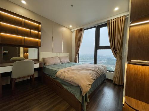 Schlafzimmer mit einem Bett, einem Schreibtisch und einem Fenster in der Unterkunft Homestay Honey Appartment Hải Phòng - Hoàng Huy Grand Tower in Haiphong