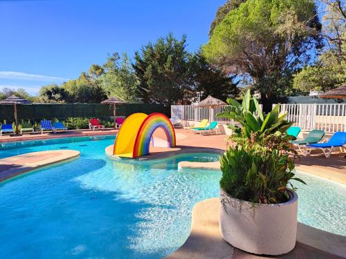 - une piscine avec un arc en arc-en-ciel et un toboggan dans l'établissement Camping la Croix du Sud, à Saint-Tropez