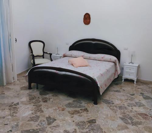 1 dormitorio con 1 cama negra y 1 silla en Cetara Sunny House, en Cetara
