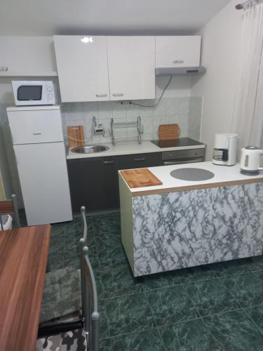 cocina con armarios blancos y suelo verde en Apartments Samaržija- new 63 not 47, en Bibinje