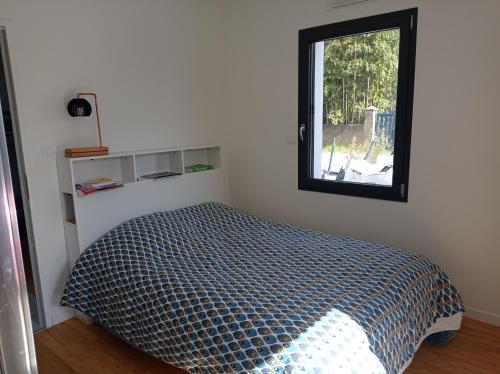 una camera da letto con un letto e una finestra di Maison neuve - Mesquer - Plage, Rando, Vélo a Mesquer