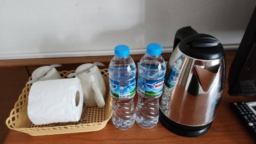 a coffee maker and two bottles of water on a table at Chalita House in Patong Beach