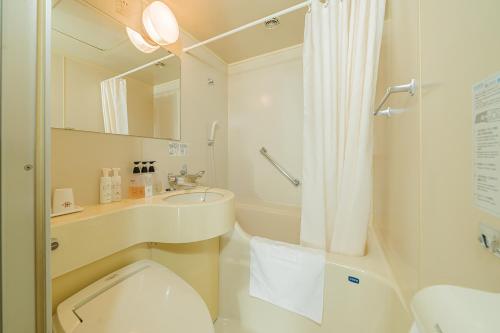 W łazience znajduje się toaleta, umywalka i prysznic. w obiekcie Kanda Station Hotel w Tokio