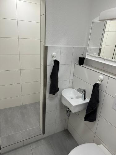un bagno bianco con lavandino e WC di 2 Zimmer Whg a Langelsheim
