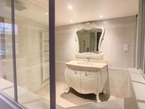 a white bathroom with a sink and a mirror at Gîte Le P'tit René in La Cresse