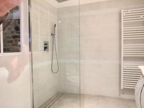 baño con ducha y puerta de cristal en Gîte Le P'tit René, en La Cresse