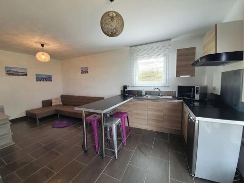 瓦朗索爾的住宿－studio à la campagne，厨房配有桌子和一些紫色凳子