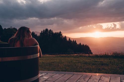 a woman sitting on a bench watching the sunset at Peterhof Chalets in Batschuns