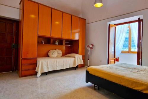 - une chambre avec 2 lits et des armoires orange dans l'établissement Trekking Lovers Vacation Home with Town View, à Minori
