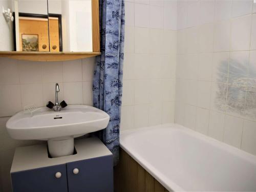 a bathroom with a sink and a bath tub at Appartement Auris, 2 pièces, 4 personnes - FR-1-297-127 in Auris