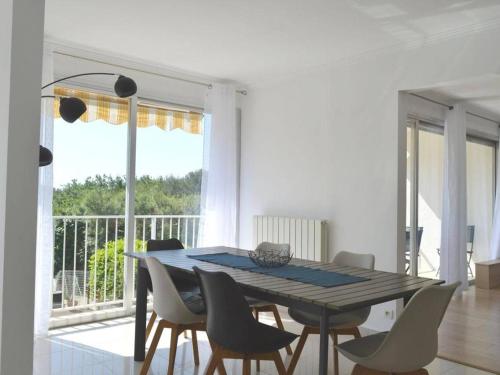une salle à manger avec une table et des chaises et un balcon dans l'établissement Maison climatisée avec piscine privée, 5 pièces, 7 couchages à 15 min des plages de Vallauris - FR-1-252-103, à Vallauris