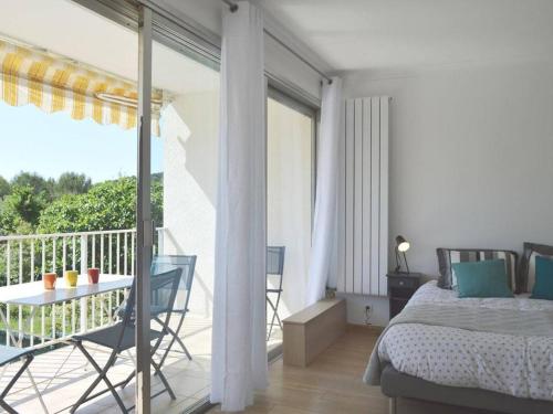 une chambre avec un lit et un balcon avec une table dans l'établissement Maison climatisée avec piscine privée, 5 pièces, 7 couchages à 15 min des plages de Vallauris - FR-1-252-103, à Vallauris