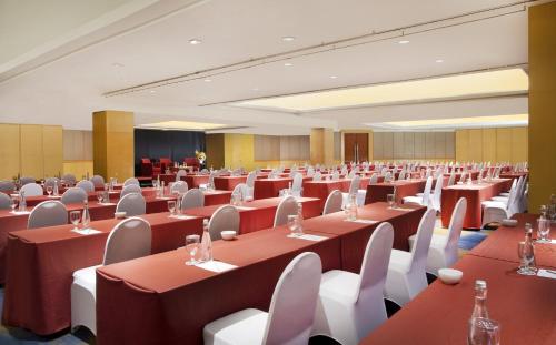 a banquet hall with red tables and white chairs at Hotel Ciputra Jakarta managed by Swiss-Belhotel International in Jakarta